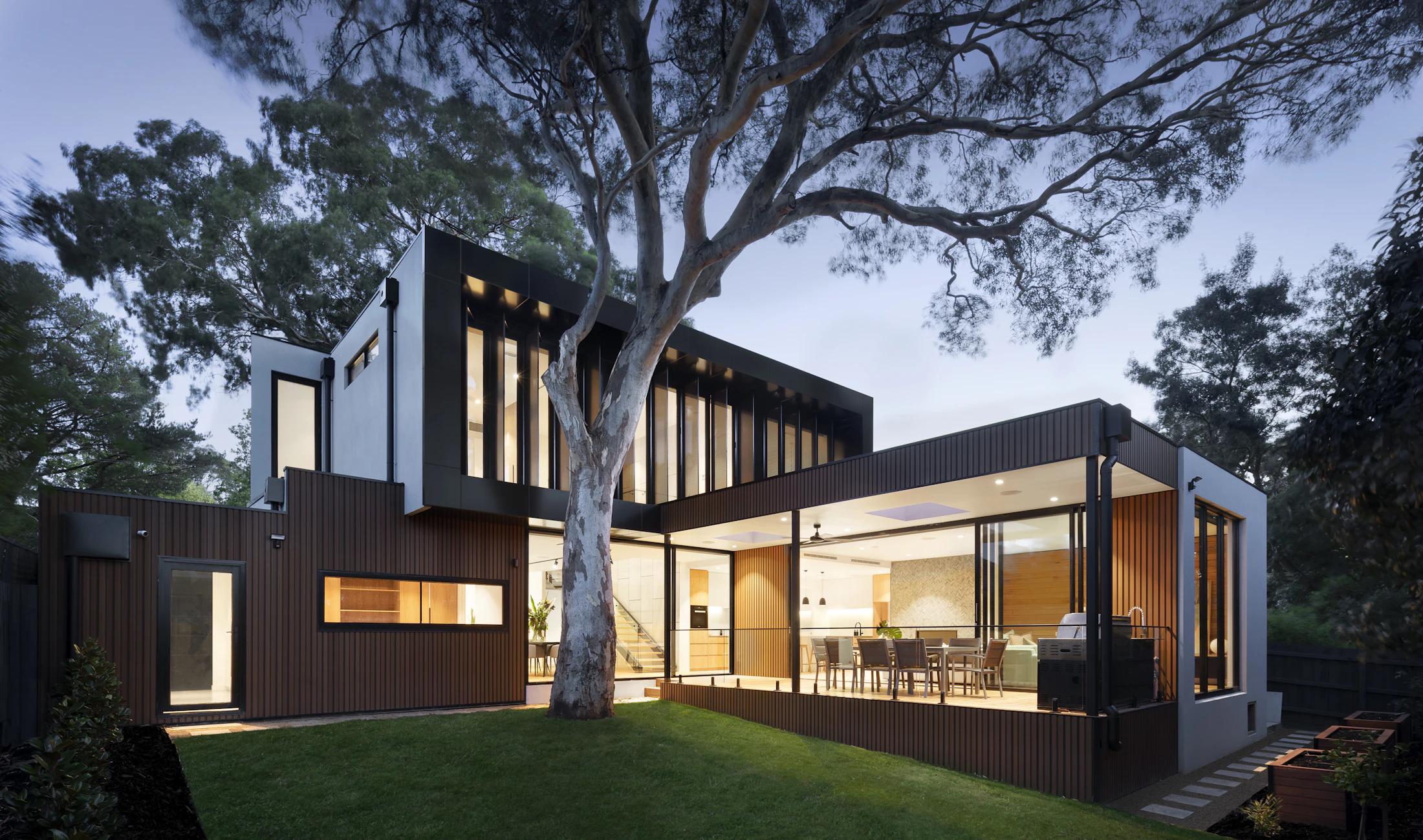 A modern home with large windows at dusk