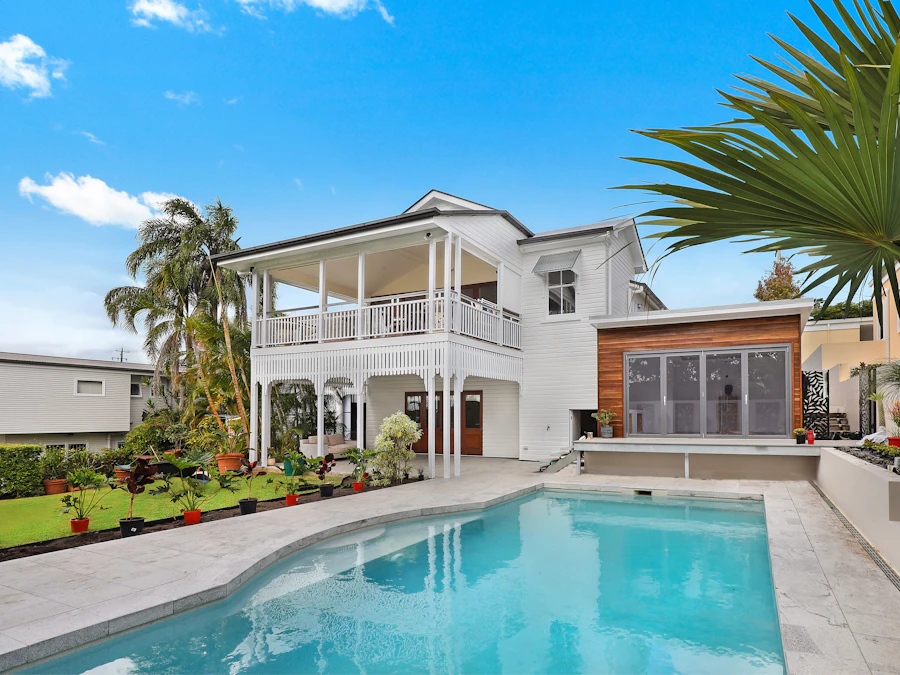 Colonial-style home with a pool and palms